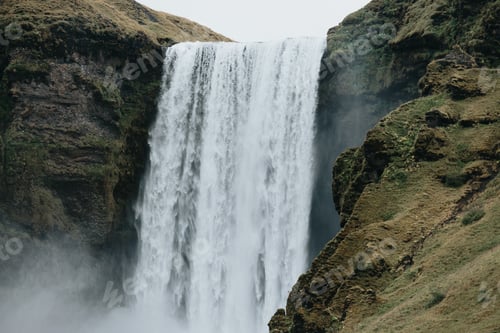 Preview: Massive skofagoss waterfall at Iceland Island during a foggy rainy day, nature landscape. Dark tones