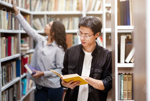 Preview: Focused japanese guy reading book at library