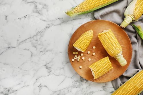Preview: Plate with tasty sweet corn cobs on marble table, top view