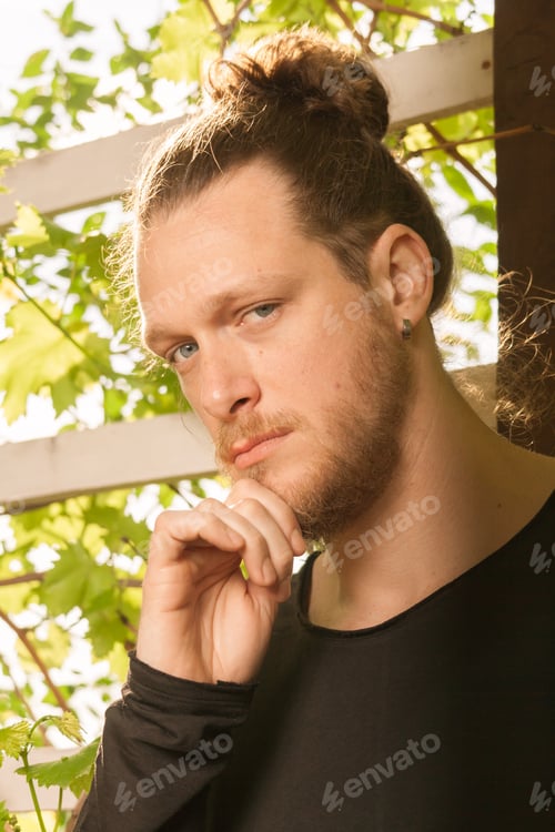 Preview: One Young Adult Caucasian Man, Looking To Camera, Portrait Head Face, Hand Touching Beard, Man Bun