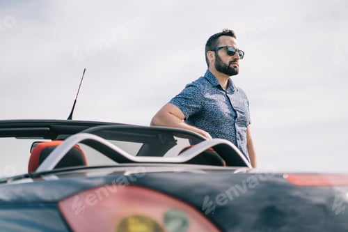 Preview: Attractive man posing in convertible car.