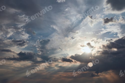 Preview: dark clouds and sun rays on blue sky background