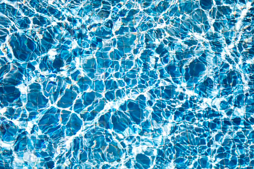 Preview: De-focused blurred transparent blue colored clear calm water surface texture with splashes