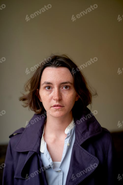 Preview: Woman with short hair in a purple coat standing against a plain background. Brussels, Belgium