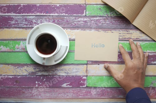 Preview: top view of men holding a hello text in blue color on a envelope