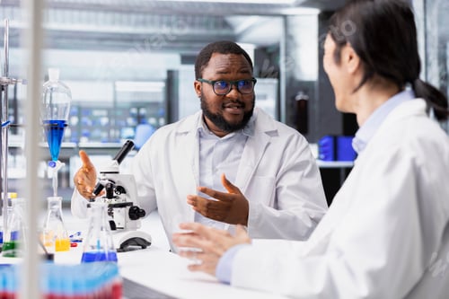 Preview: Multiethnic team of microbiologists in laboratory inspecting specimen slide