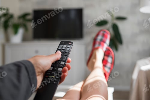 Preview: Hand with TV remote control in living room