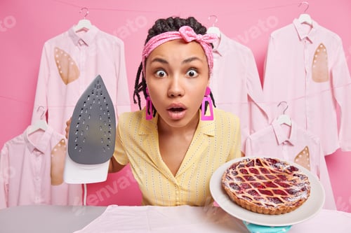 Preview: Shocked ethnic woman stares bugged eyes at camera wears headband and dress has much domestic work an