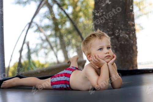 Young Child Relaxing on an Outdoor Trampoline