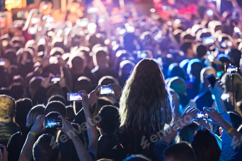 Preview: The silhouettes of concert crowd in front of bright stage lights