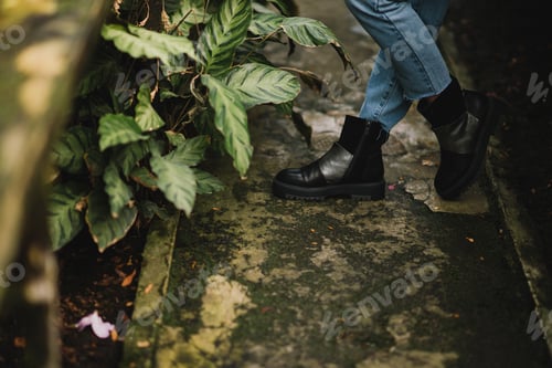 Preview: Young caucasian woman in glass greenhouse among azalea flowers. Feet closeup.