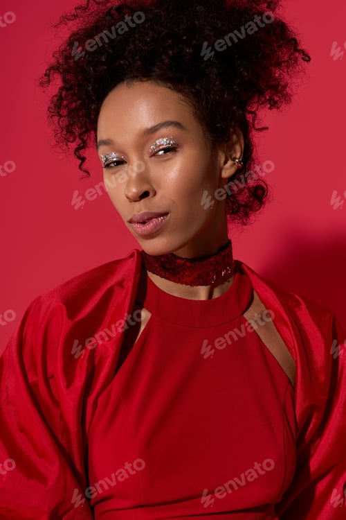 Preview: Young beautiful woman radiates confidence against a vibrant red background