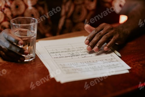 Preview: Unrecognizable Man With Sheet Music On Table
