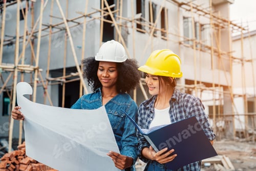 Preview: Young female architector and engineers working on building site.
