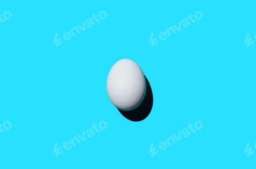 Preview: Single egg on a blue background, top view. Minimalism art photo, design, copy space.