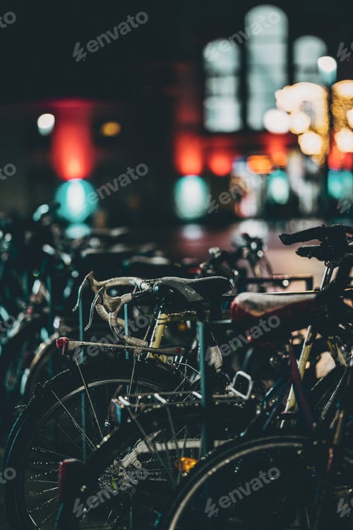 Preview: Vertical shot of parked bicycles at night.