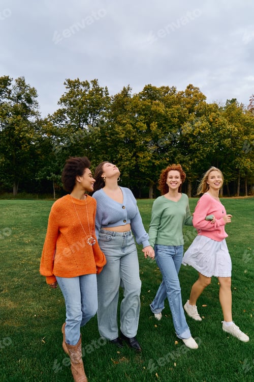Preview: Friends enjoying a sunny spring day while strolling through a lush green park together
