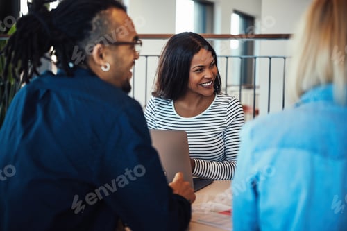 Preview: Young African American businesswoman laughing with office colleagues