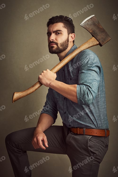 Preview: Studio shot of a young man posing with an axe against a green background