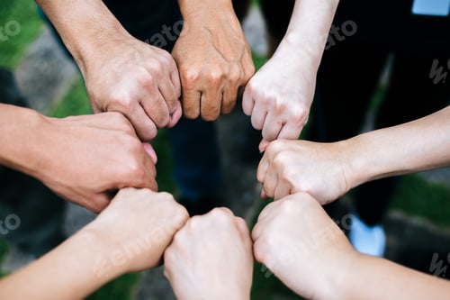 Preview: Close up of students standing hands making fist bump gesture.