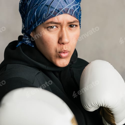 Preview: Young Islamic woman wearing a sport hijab while boxing