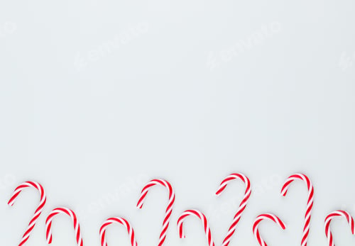 Preview: Christmas candy cane lied on blue background. Flat lay and top view.