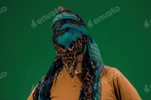 Preview: man with face covered by a scarf on a green background