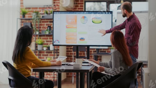 Preview: Business man doing financial presentation for partners in office