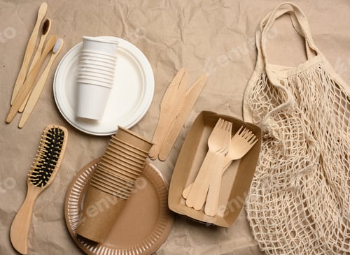 Preview: White string bag with disposable paper dishes and wooden forks on brown kraft paper