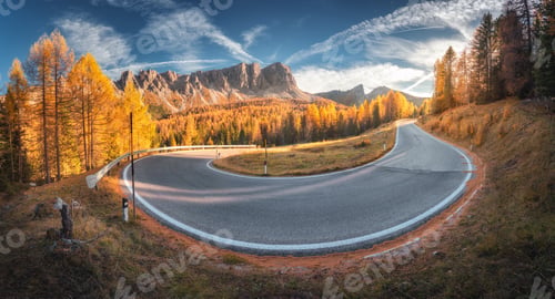 Preview: Winding road in mountains and orange trees at colorful sunset