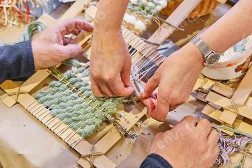 Preview: Hands Weaving Small Tapestry on Wooden Frame. Weaving master class in craft workshop