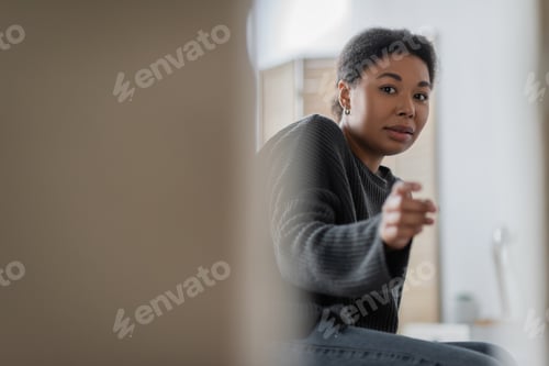 Preview: Worried multiracial woman with psychological problem pointing at camera at home