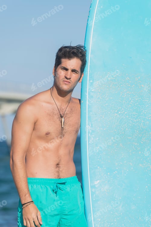 Preview: Surfer holding his blue surfboard
