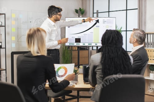 Preview: Team of diverse attentive mixed race business people listening their middle aged male indian chief