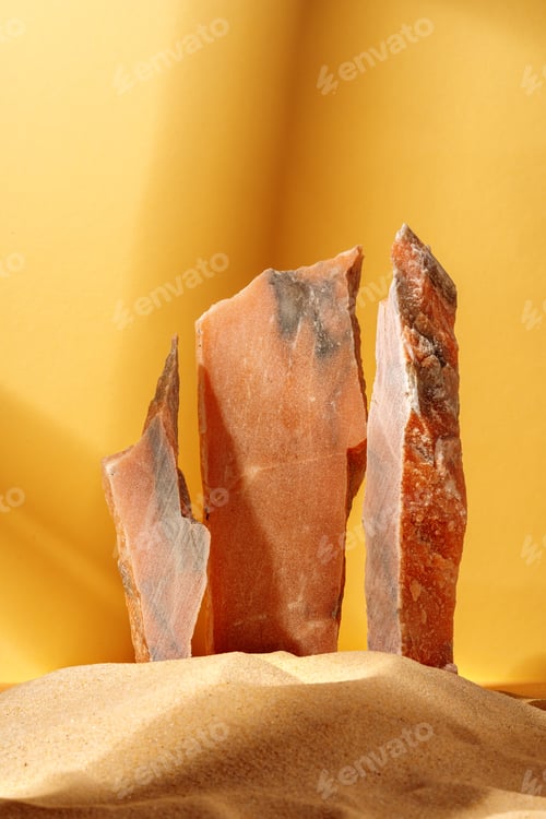 Preview: Marble rocks in sand against yellow background