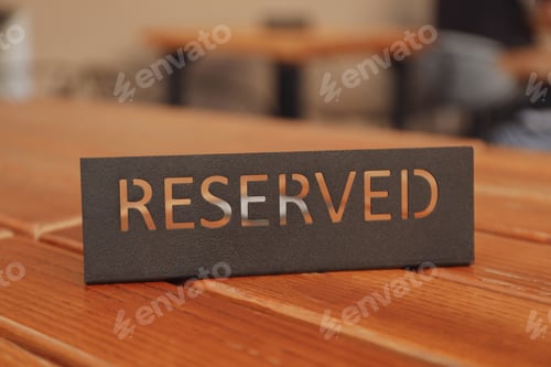 Preview: Wooden table with Reserved sign, close up