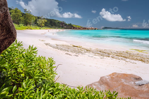 Preview: Tropical coast at La Digue island, Seychelles. Lush green vegetation, turquoise blue ocean on long