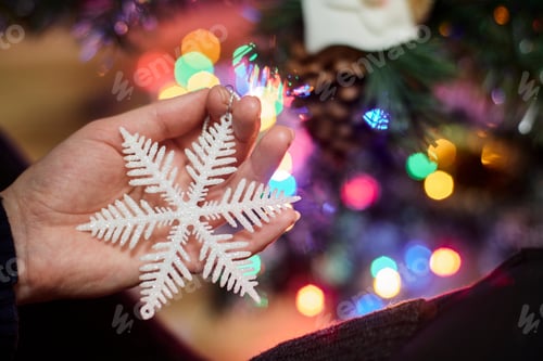 Preview: Woman's hand holding Christmas ornament, close-up