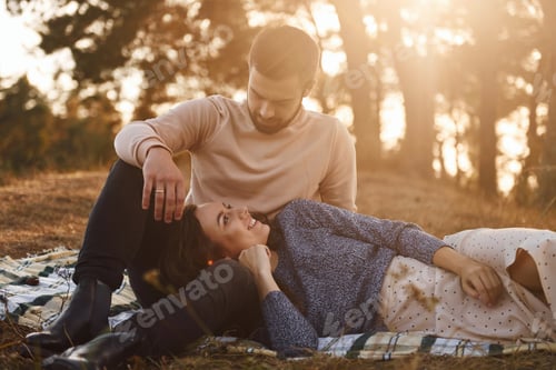 Preview: On picnic. Cheerful lovely young couple having a rest outdoors together