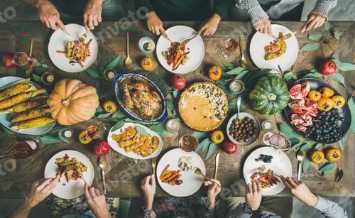 Preview: Friends eating at Thanksgiving Day table with turkey and snacks