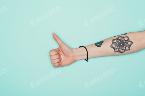 Preview: cropped shot of woman showing thumb up isolated on turquoise