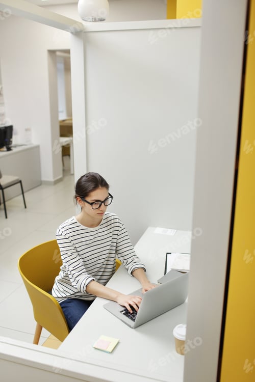 Preview: Young woman typing on laptop