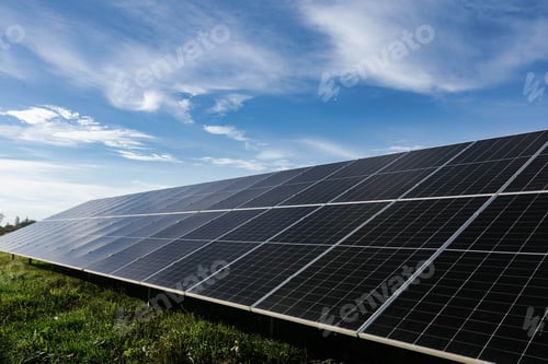 Preview: Solar panels absorbing sunlight under a cloudy blue sky