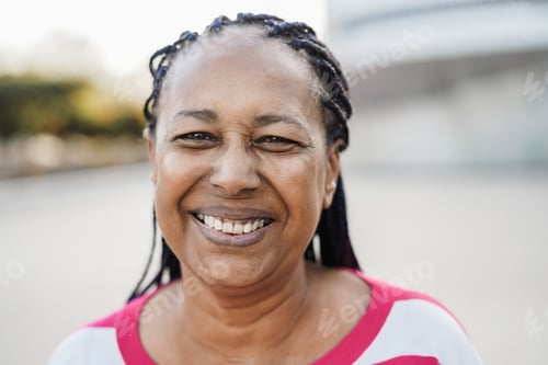 Preview: Senior african woman smiling on camera outdoor in the city - Focus on face