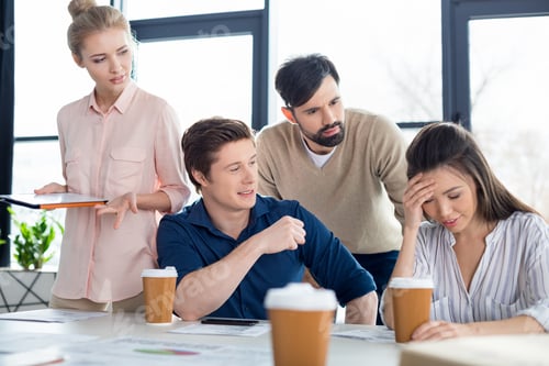 Preview: group of young business people looking at colleague on small business meeting