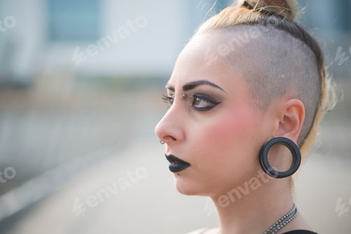 Preview: Portrait of young female punk with earlobe piercing and shaved head