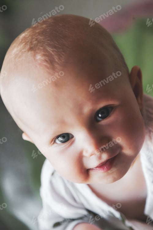 Preview: Portrait smiling little kid looking at camera in his infant cot