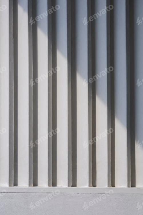 Preview: Sunlight and shadow on surface of white wooden sunshade battens on cement wall in vertical frame