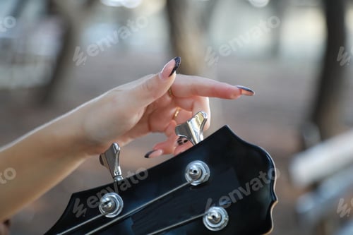 Preview: Girl Adjust Handles To Tune Bass Musical Instrument In The Park