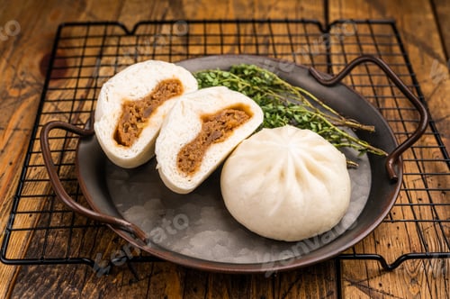 Preview: Chinese Bao Baozi steam bun with meat on steel tray. wooden background. top view